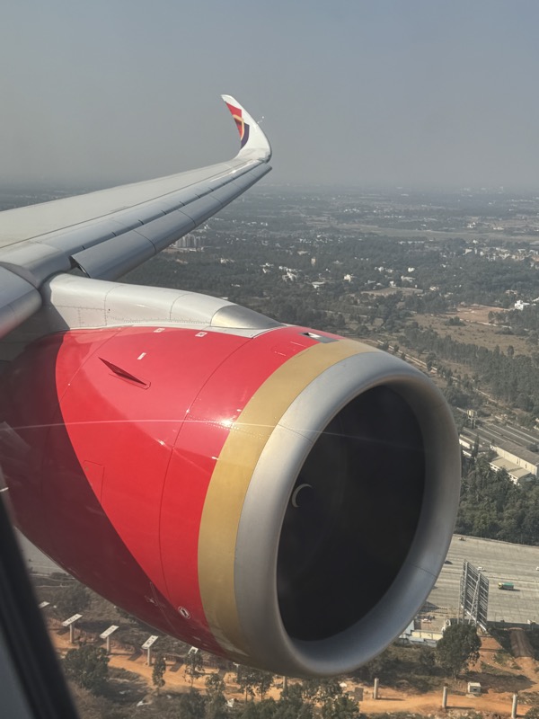 an airplane wing with a city in the background