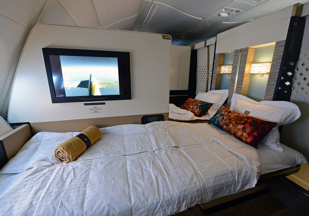 a bed with a tv on the wall