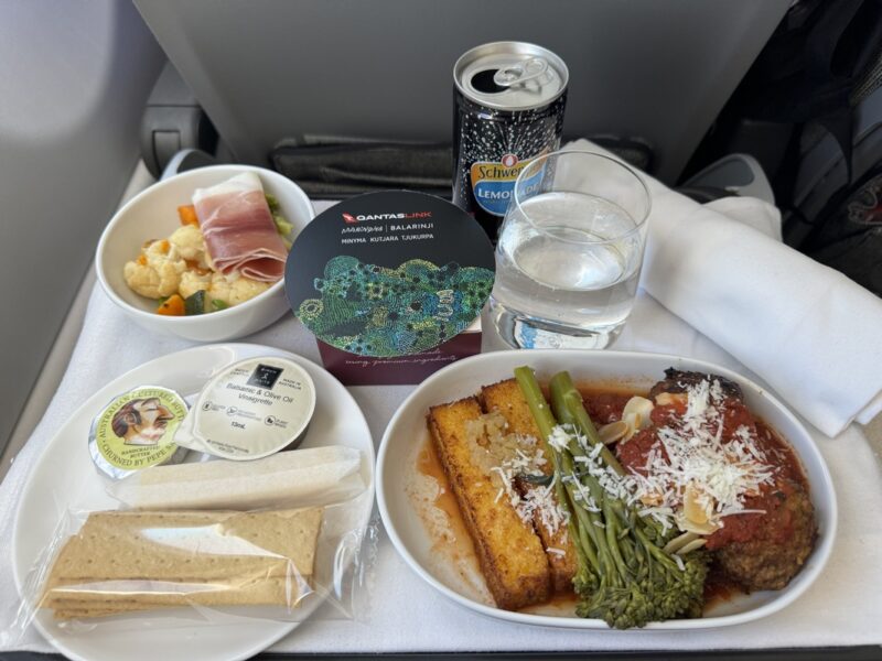 food on a tray with a drink and a plate of food