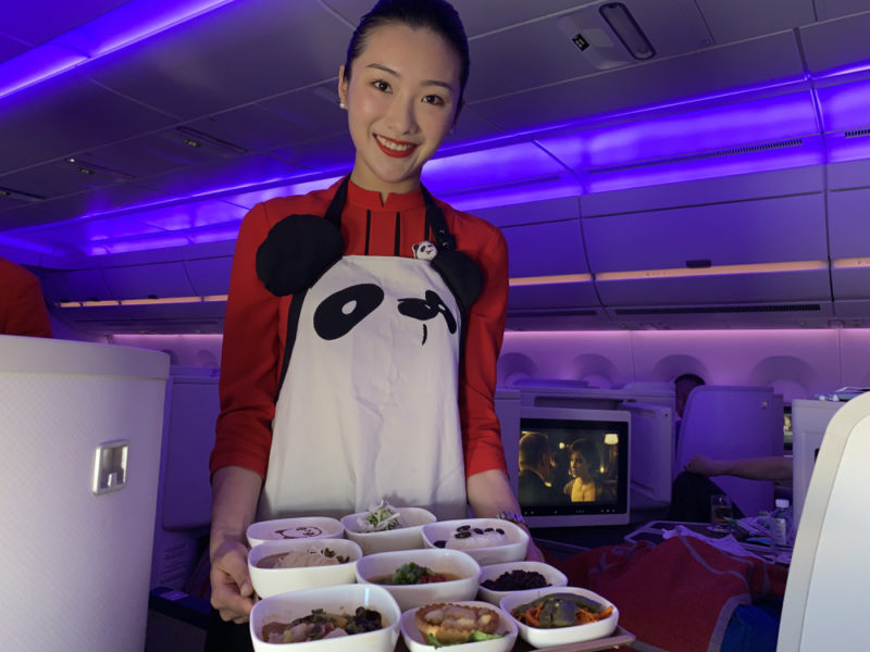 a woman in an apron holding a tray of food