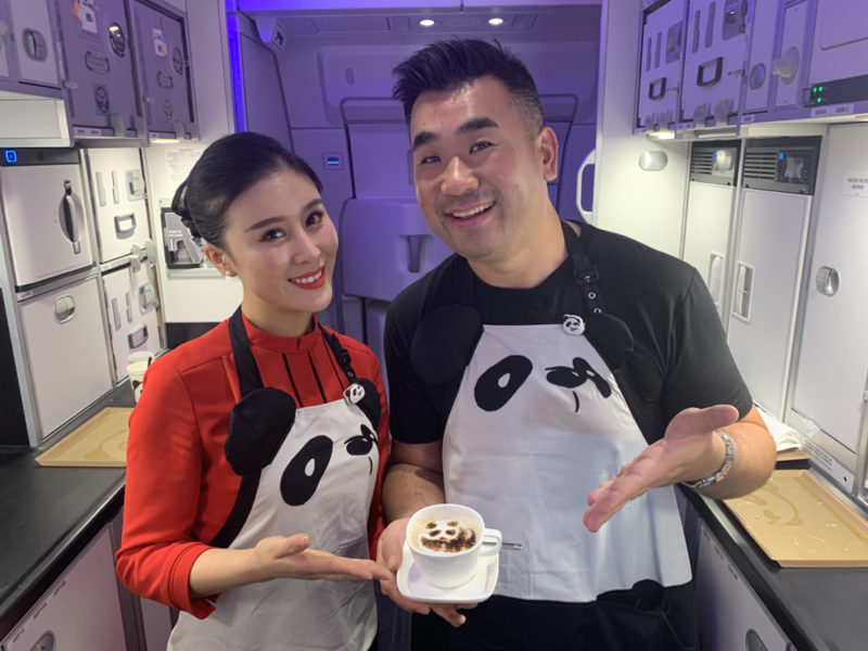 a man and woman in aprons holding a cup of coffee