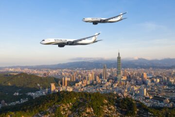 two airplanes flying over a city